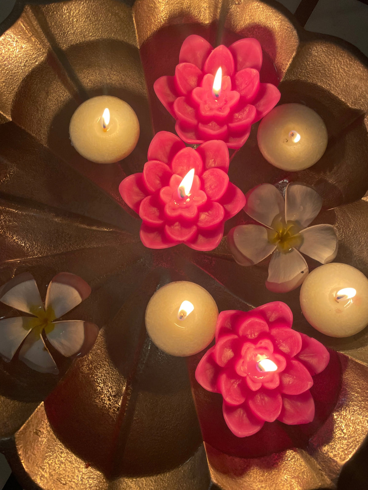 Indiglow lotus flower floating candle for decorative water displays shown in evening settings.